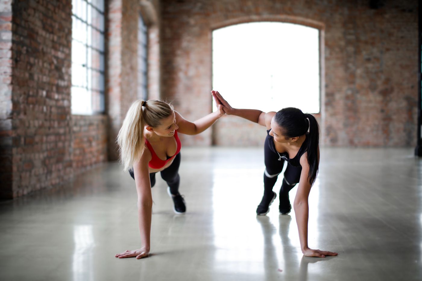 Two women sharing a high-five during a workout